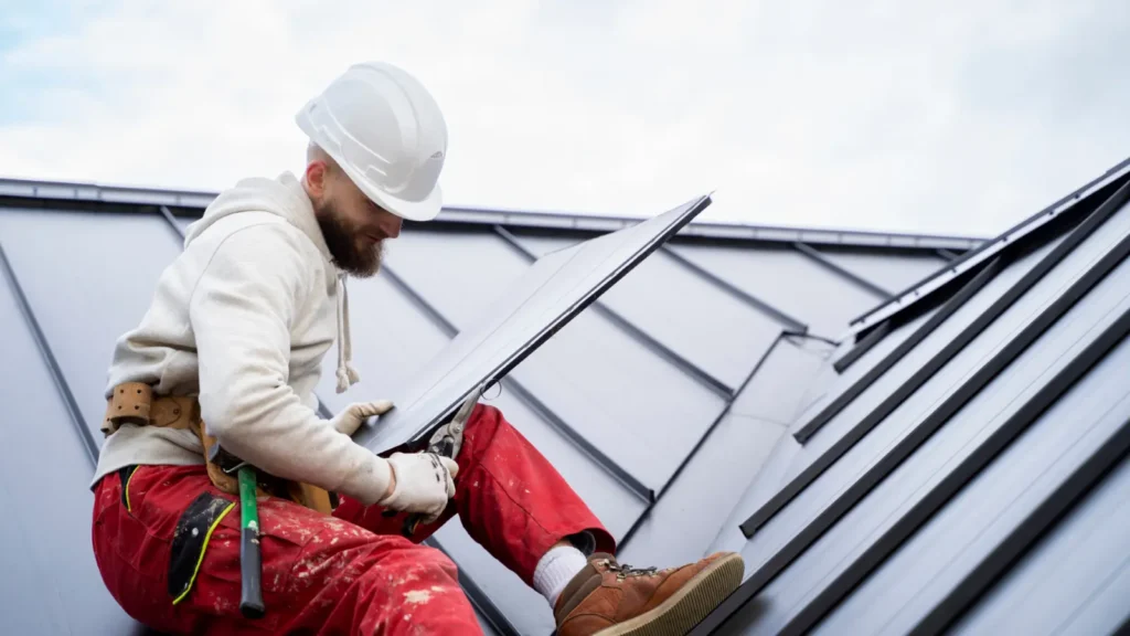 Residential roofing contractor in Long Beach installing a sleek metal roof panel, showcasing quality home roofing services