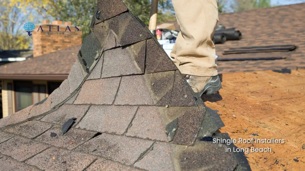 Professional roofer installing asphalt shingles on a residential roof in Long Beach