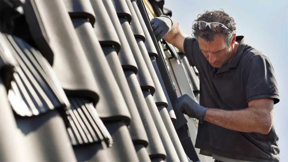 Professional roofing contractor repairing shingle roof in Long Beach