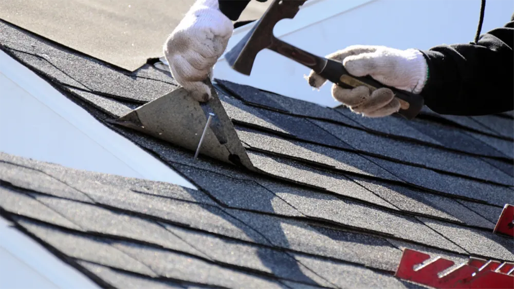Roofing contractor installing shingles on coastal Long Beach roof